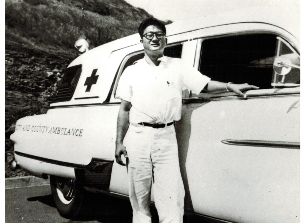 City and County crew member next to his Packard ambulance